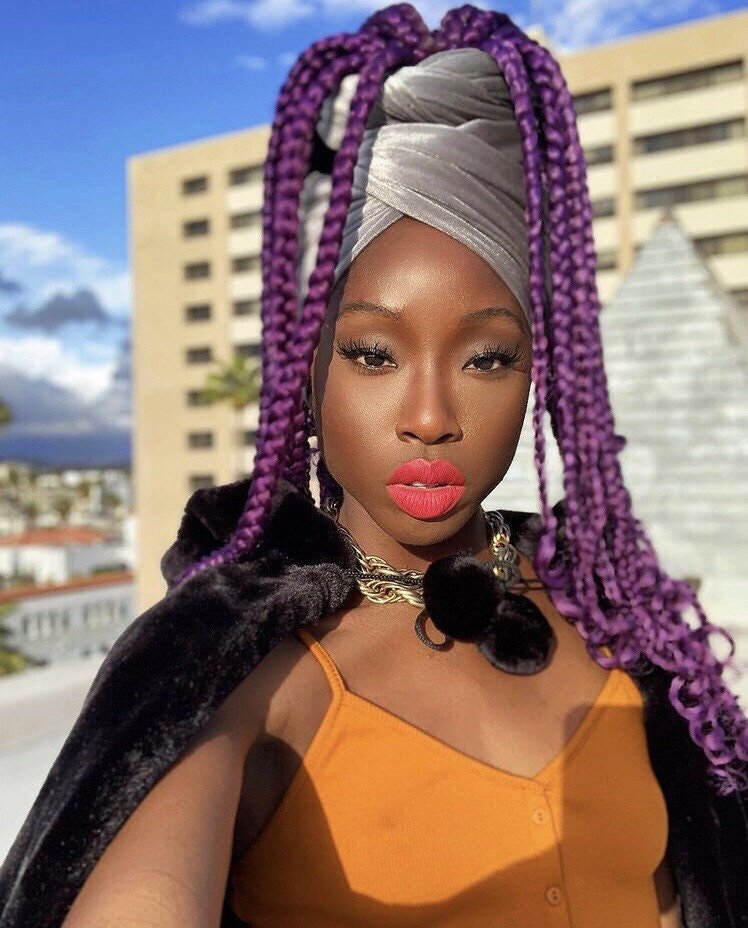 Black woman in front of building with silver wrap