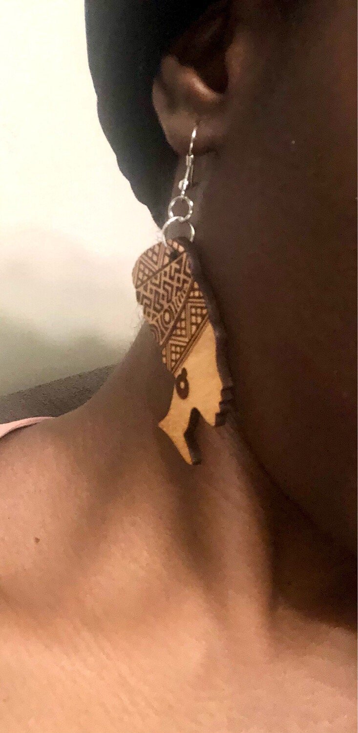 Black woman wearing earrings showing right side