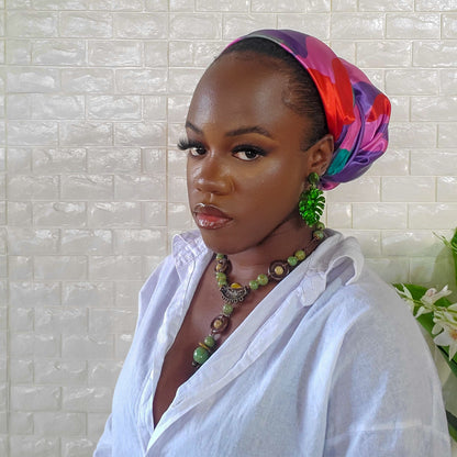 Model posing with scarf that has red, purple and red tones